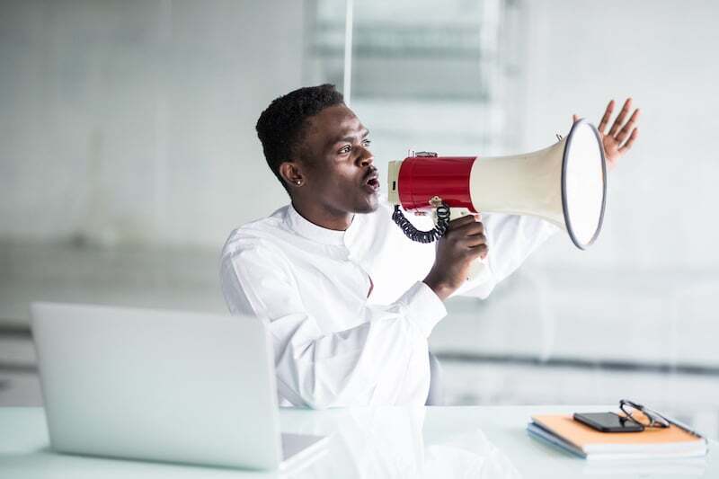 businessman-scream-yelling-through-megaphone-in-the-office