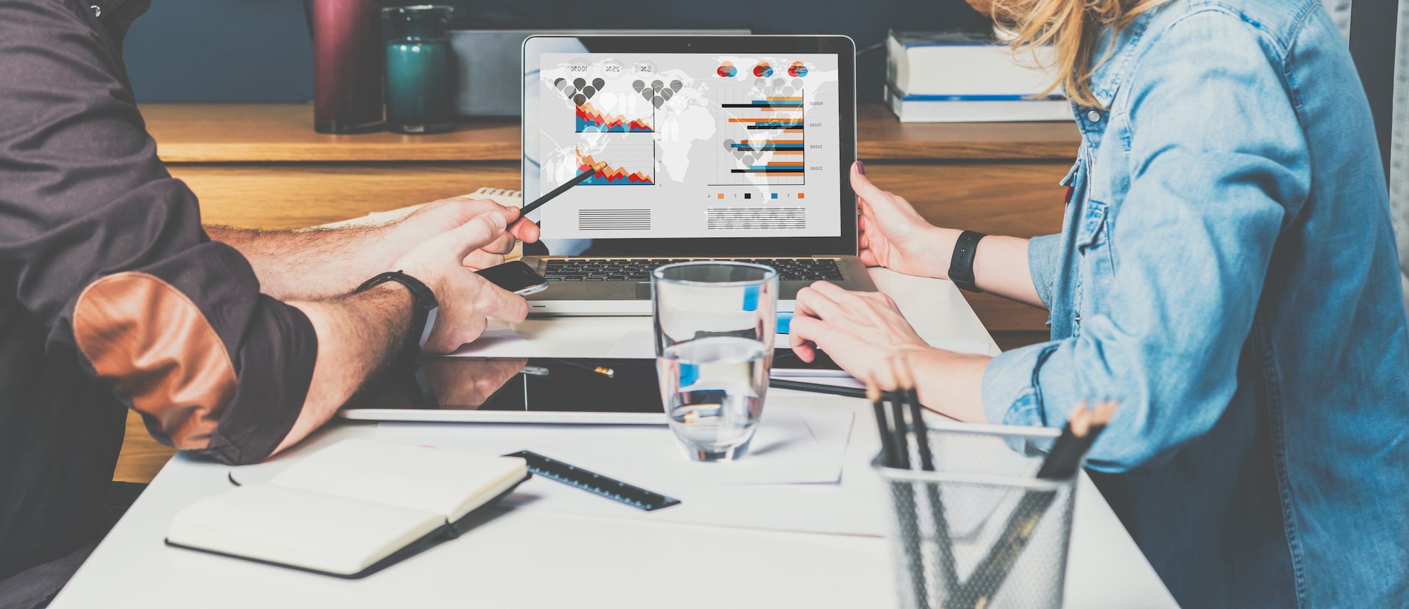 Photo centrée sur un ordinateur d'un homme et une femme qui regardent des statistiques
